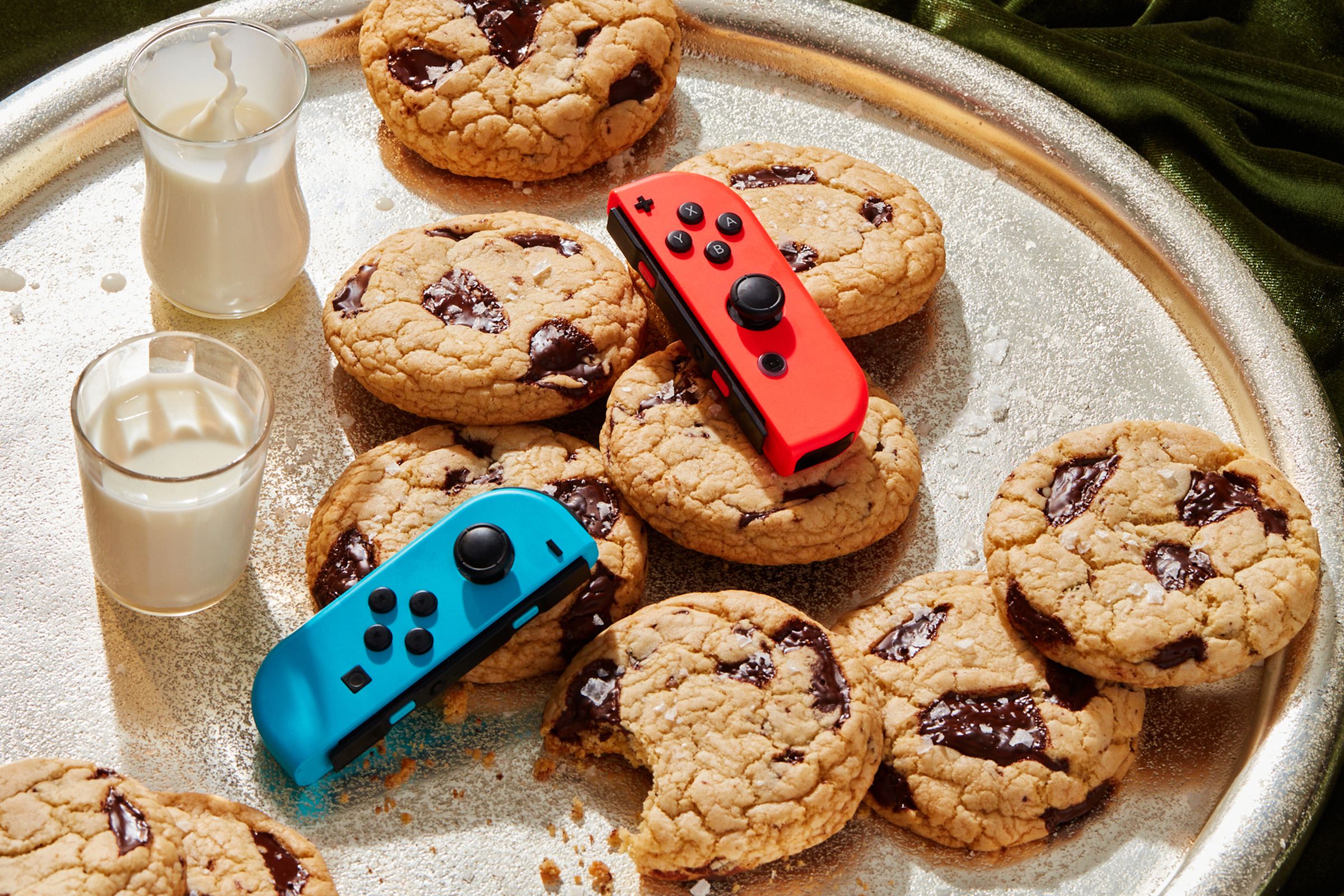 Nintendo Switch Joy-Con controllers on a tray of milk and cookies