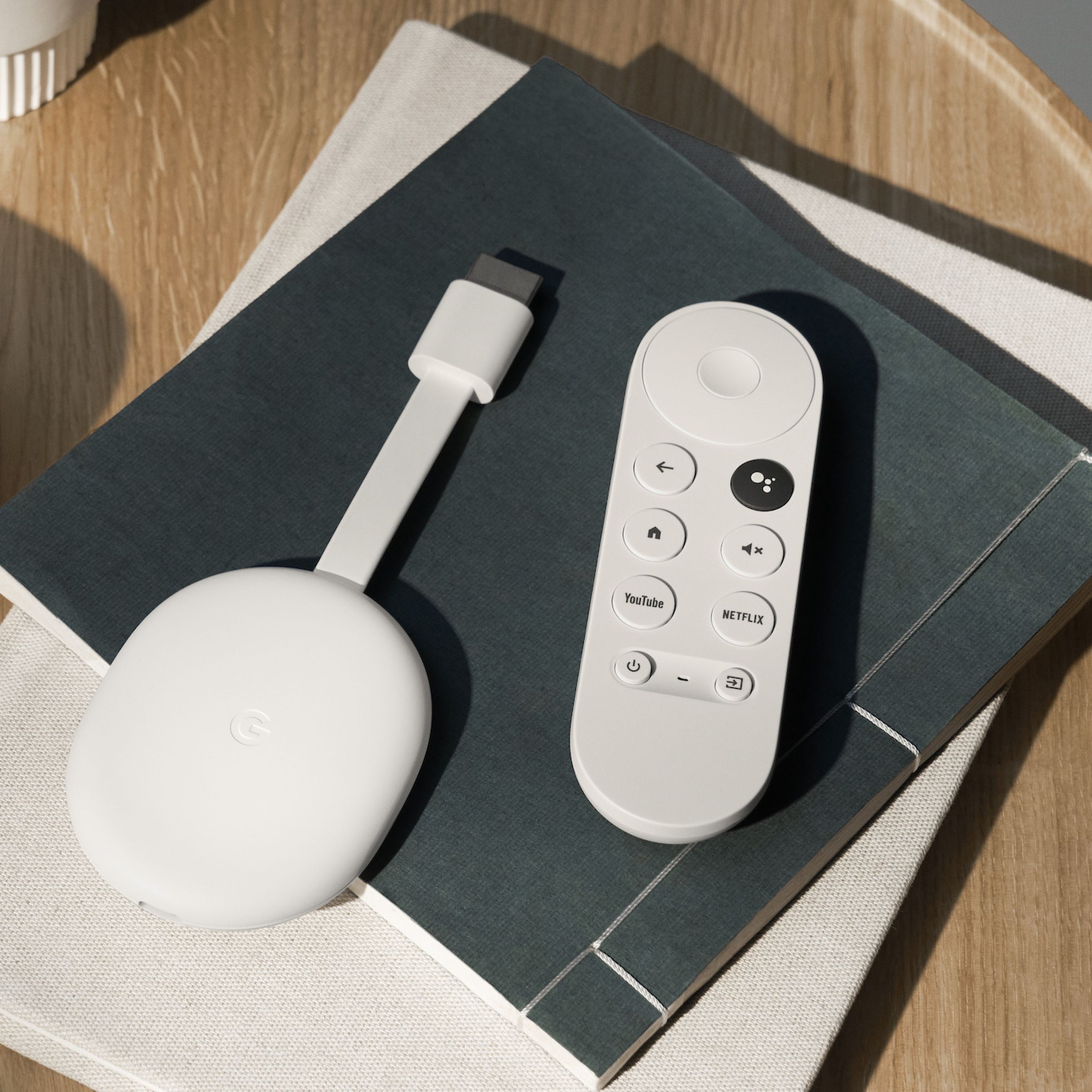 An image of the Chromecast with Google TV HD streaming player on a coffee table.