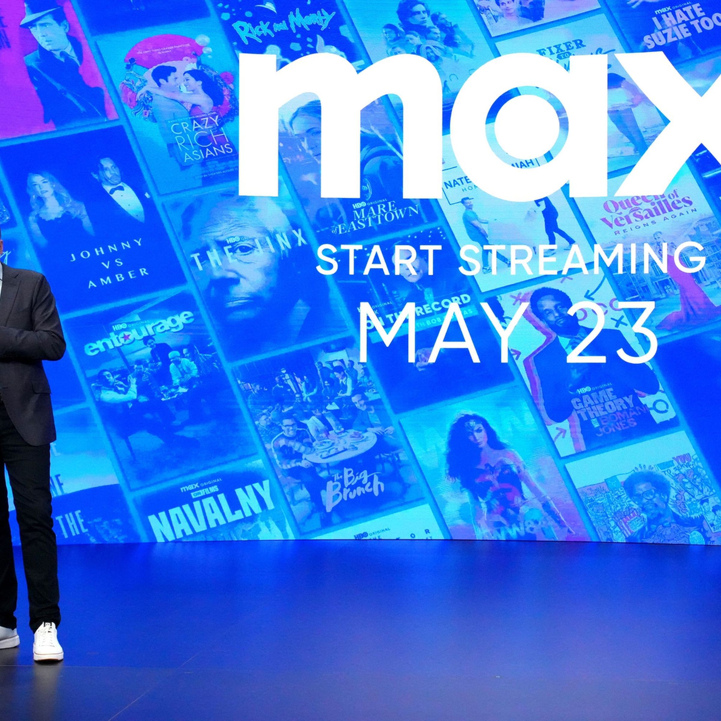 A picture of chair and CEO of HBO and Max content, Casey Bloys, standing in front of the Max logo.