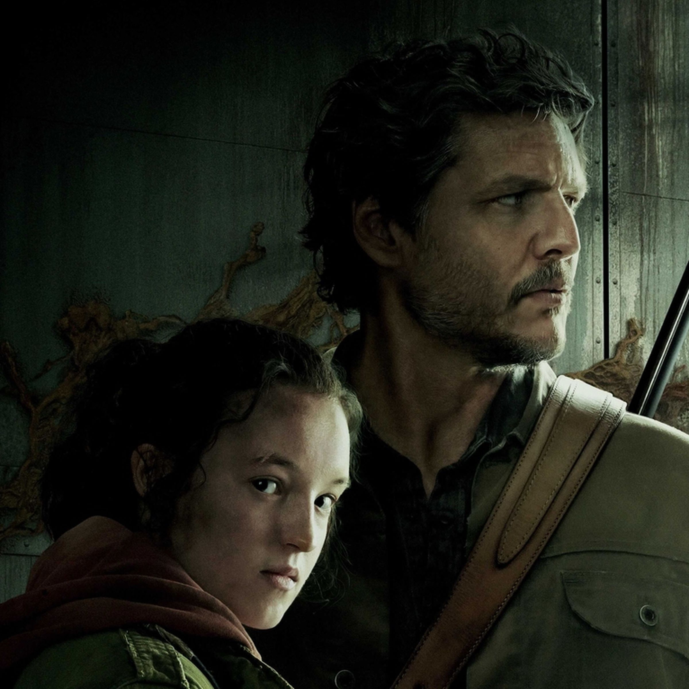Bella Ramsey (Ellie) with her head lying against Pedro Pascal’s (Joel) chest as he holds up a gun and looks the other way.