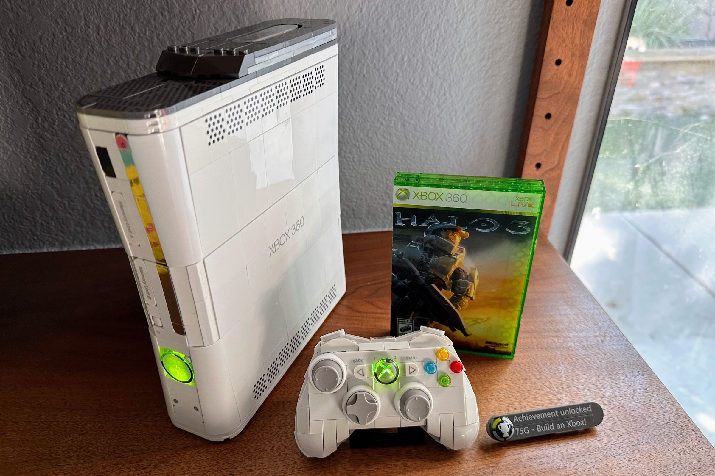 A white Xbox 360 with a hard drive, controller, and a “copy” of Halo 3 — you build them all with bricks.